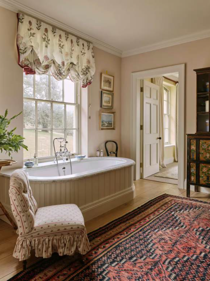 Ruched Austrian blinds, antiques, rugs and a skirted slipper chair for tub-side chats all bring luxurious comfort to this room by Octavia Dickinson ... who is a big fan of ‘a sociable bathroom’ and always keen to persuade a client to a woollen carpet
